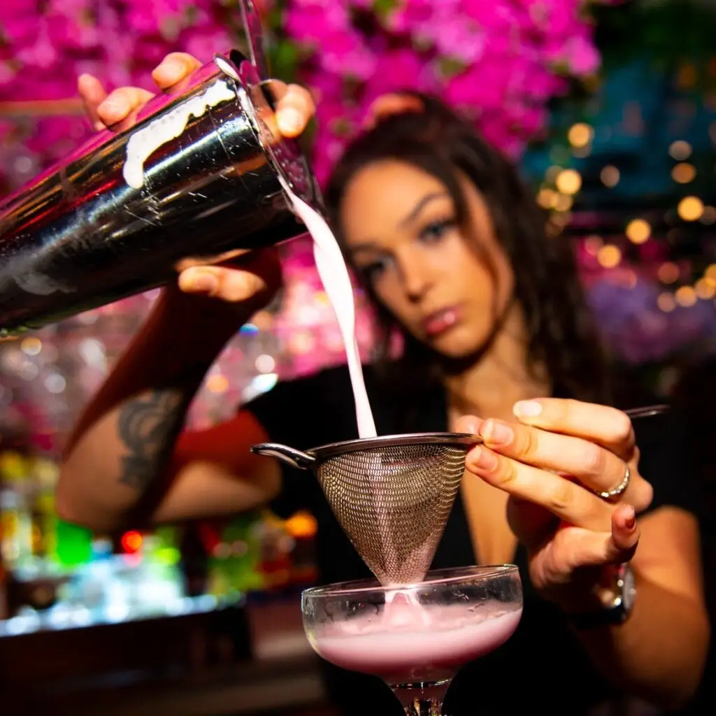 Bartender straining a cocktail