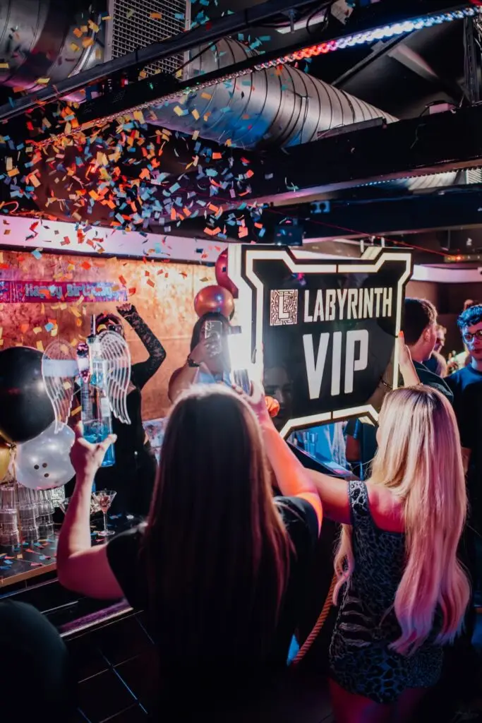 Confetti and balloons at a VIP table with the Labyrinth VIP sign